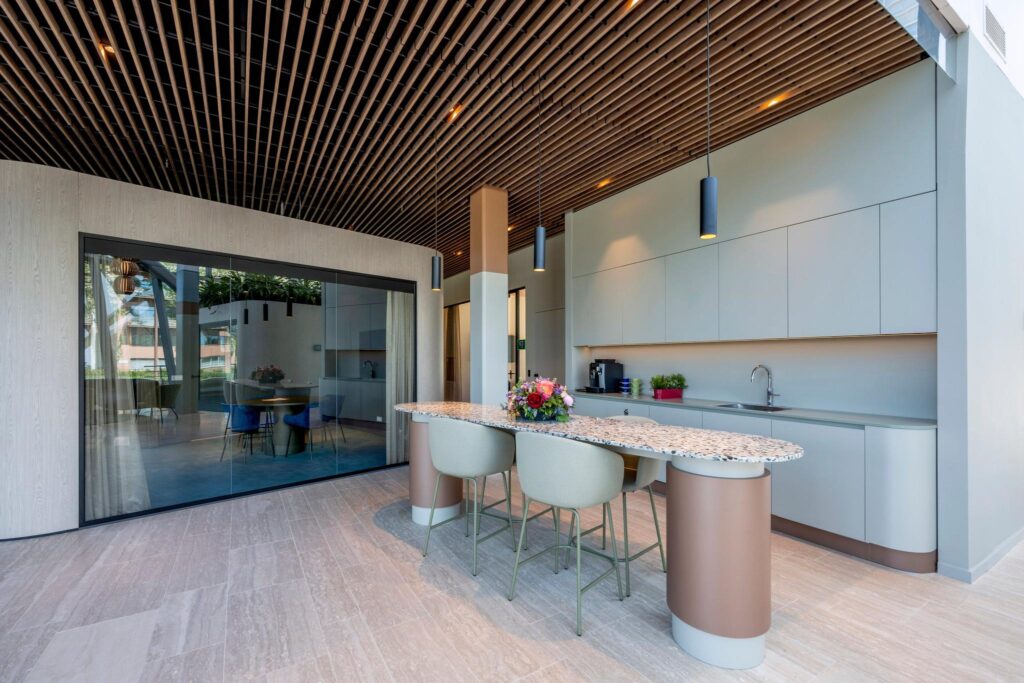 Moderne open keuken met een terrazzo kookeiland, strakke kastenwand en uitzicht op een eetruimte aan de David Ricardostraat.